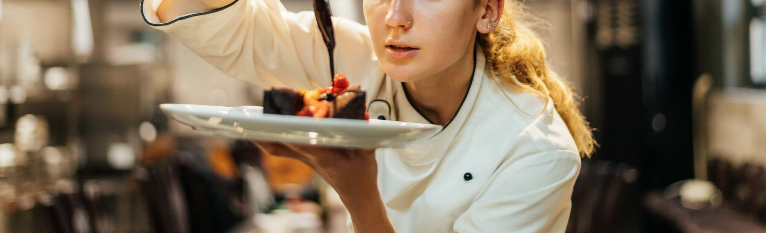 female-chef-carefully-pouring-sauce-dish-2-scaled.jpg?w=1024&h=311&scale