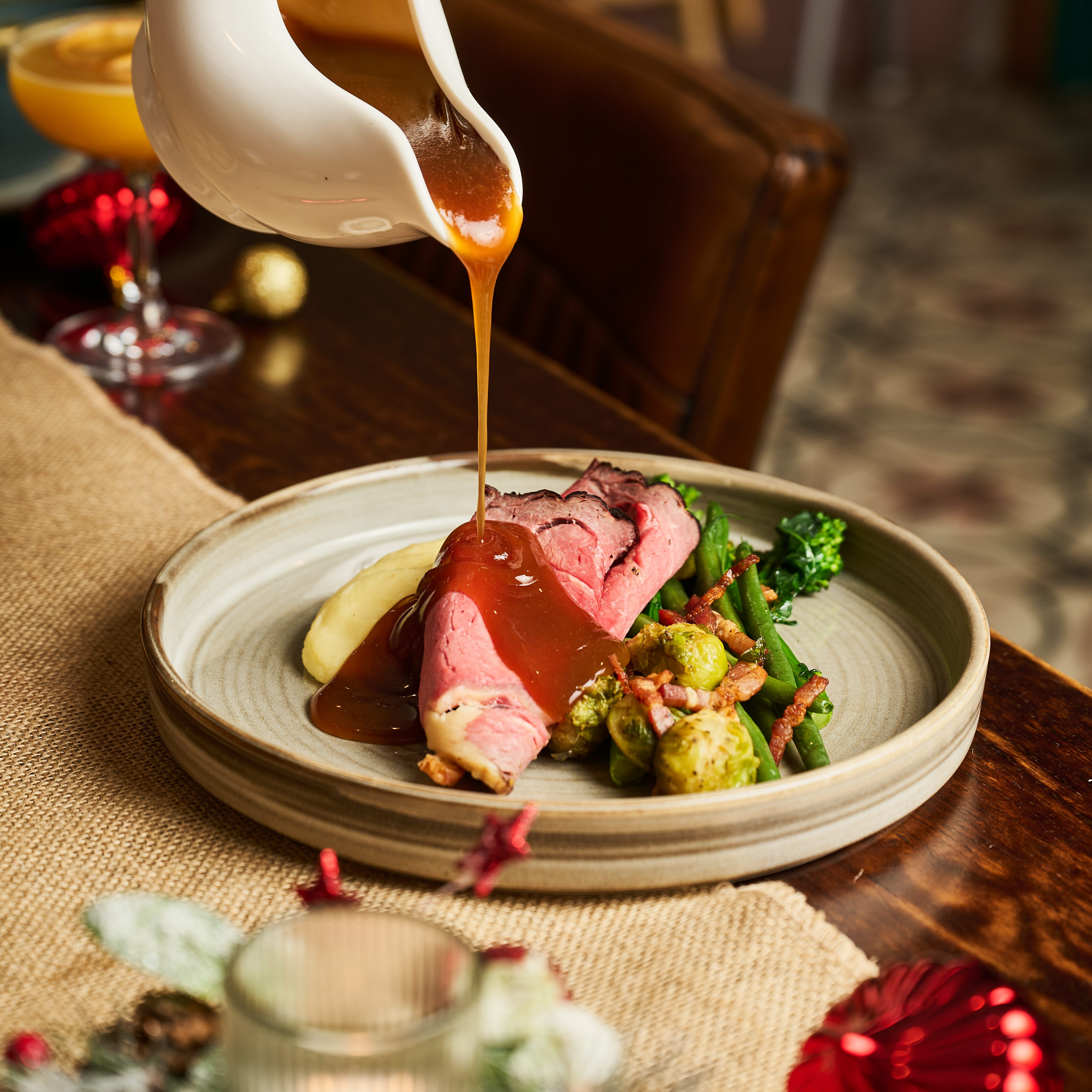 Gravy being poured over beef in The Maple Restaurant Cleeve